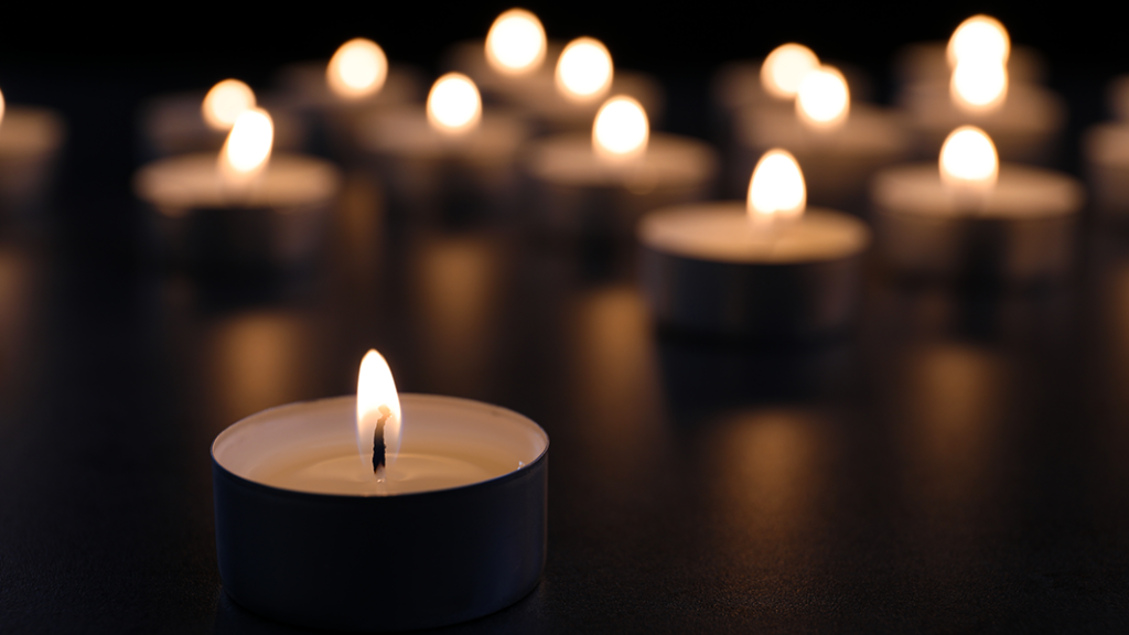 Record UK alcohol deaths in 2022 Burning candle on table in darkness, Funeral symbol, in memory of alcoholic parent