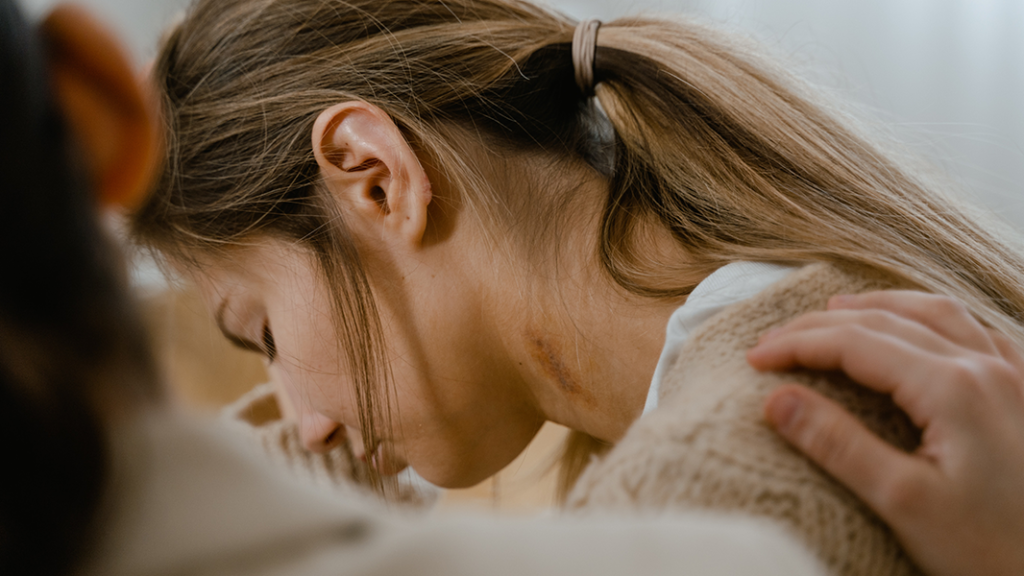 Person with hand on shoulder of a sad-looking woman to represent someone trying to help an alcoholic person