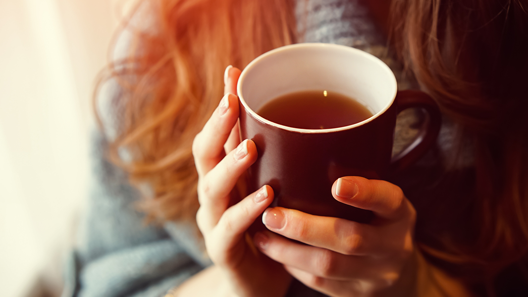 Person holding mug of tea to represent taking time to look after yourself