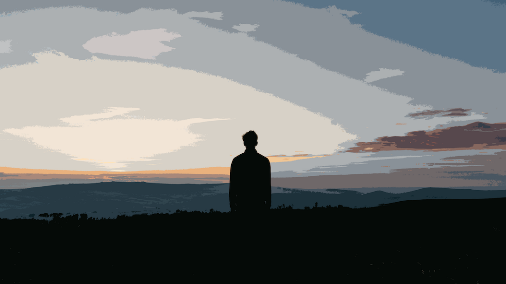 Silhouette of a person looking to the horizon with a blue and orange sky to represent someone grieving when a parent dies due to drinking too much alcohol