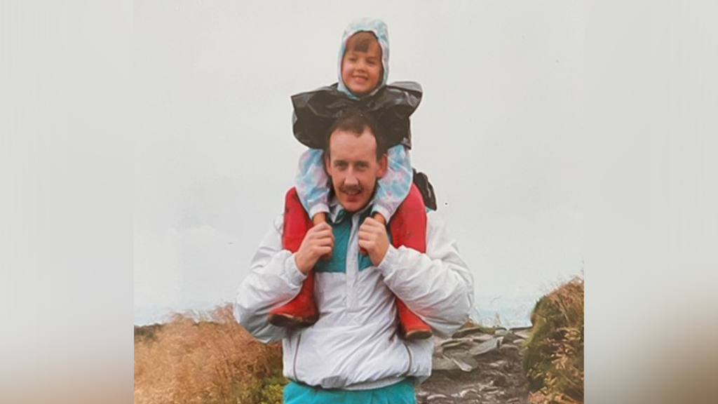 child smiling whilst sitting on father's shoulders outside before he became alcoholic and died