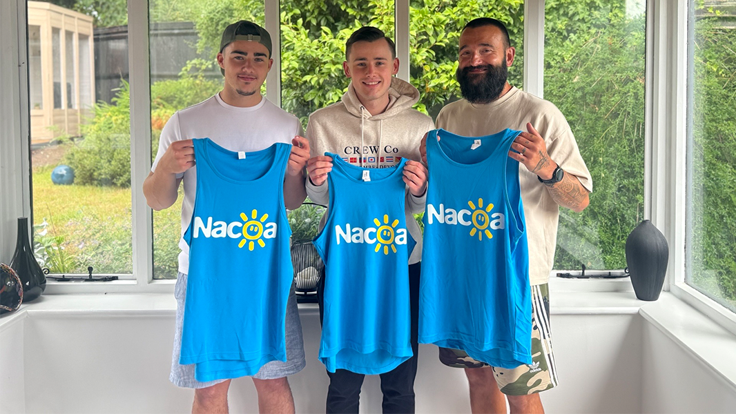 Charlie, Quinn and their uncle Robbie holding blue Nacoa charity running vests as they prepare to run the West Coast half marathon. They are running as a tribute to Charlie and Quinn's dad Karlos who died from cirrhosis due to alcoholism.